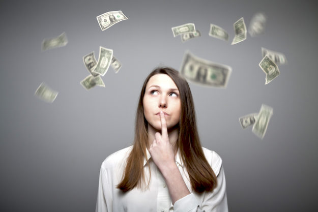 Young woman thinking about dollar bills flying Employee Pay Adjustment